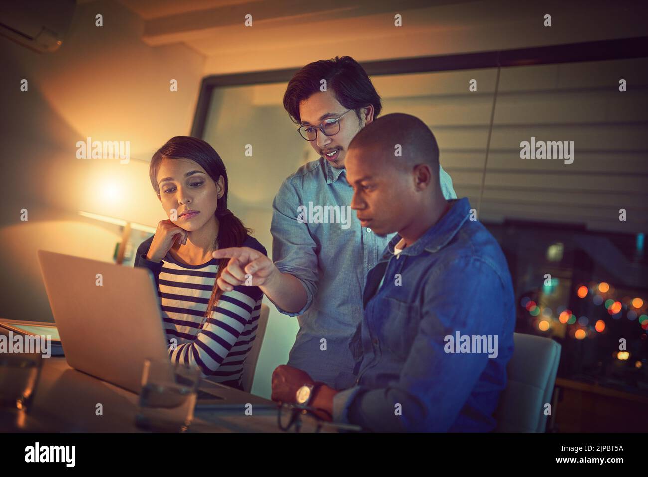 That right there could be our solution. a group of designers working late in an office. Stock Photo