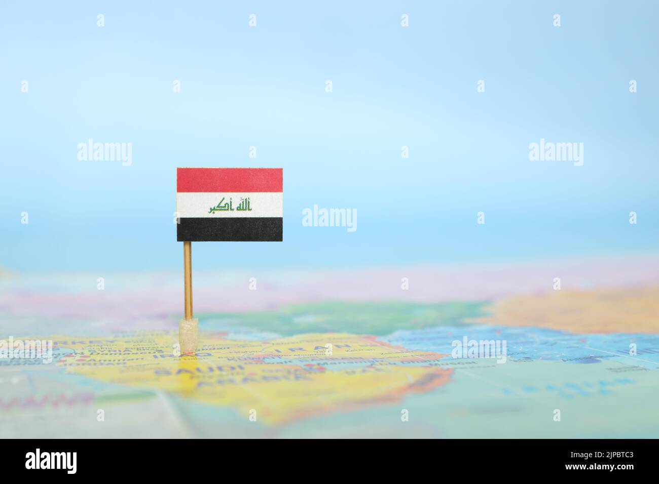 Selective focus of Iraqi flag in world map. Iraq country location and sovereignty concept. Stock Photo