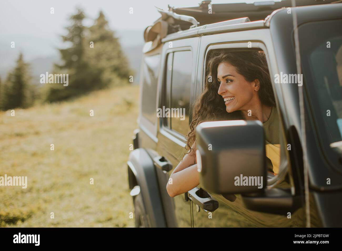 Pretty young woman enjoying freedom in terrain vehicle on a sunny day Stock Photo