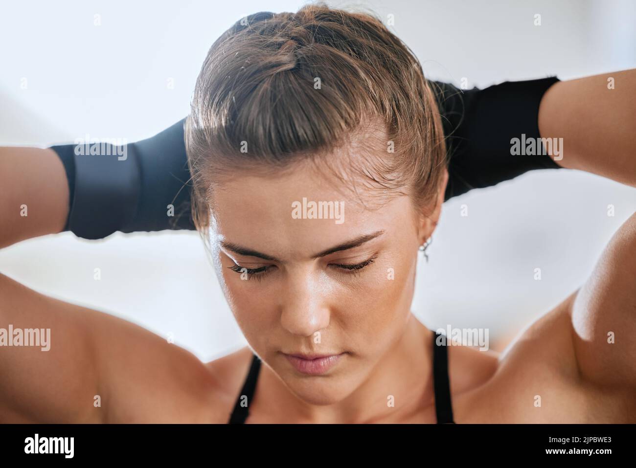 Face of a young female boxer getting ready to train in the gym for a