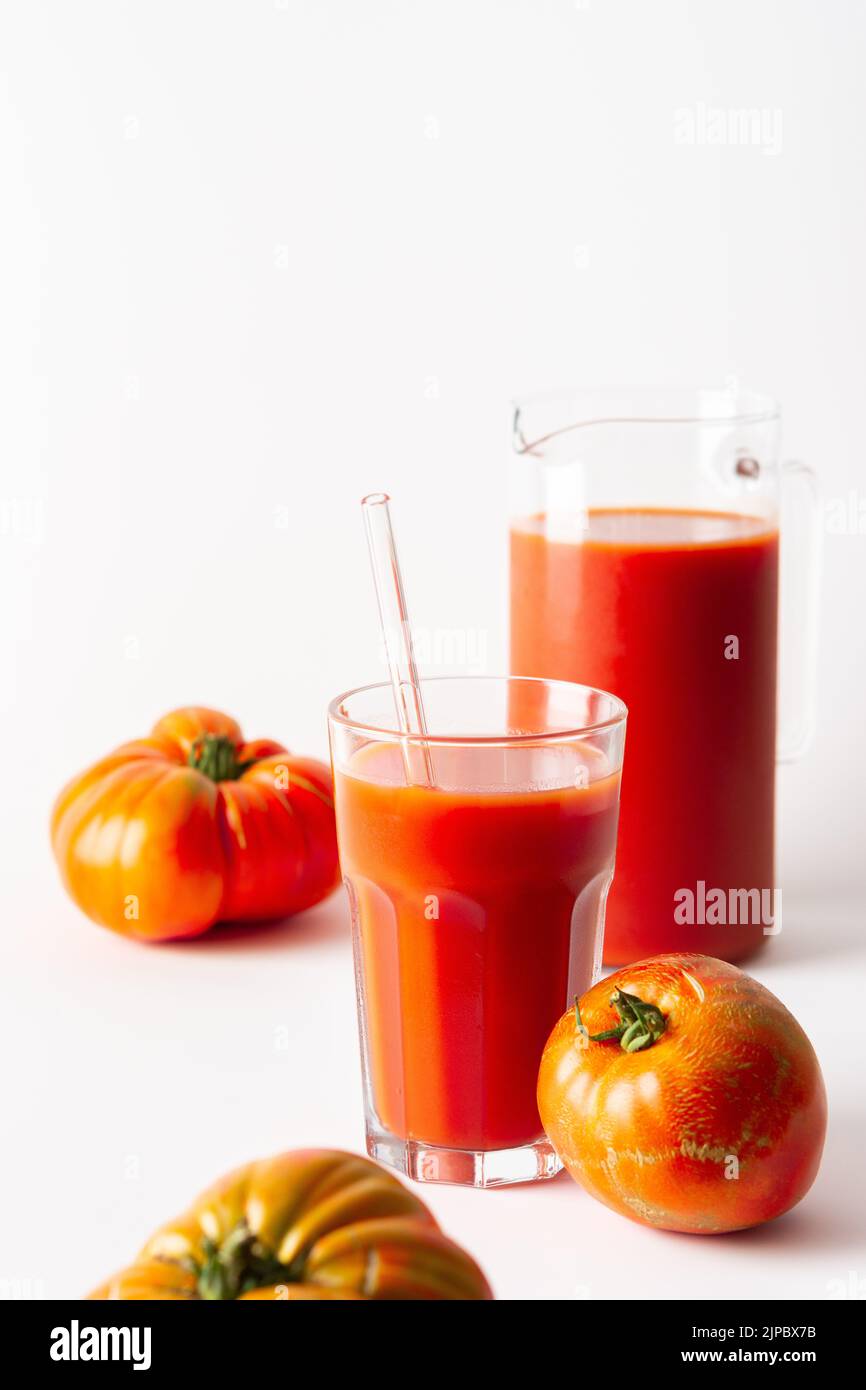 Homemade freshly squeezed tomato juice in a glass and a jug with