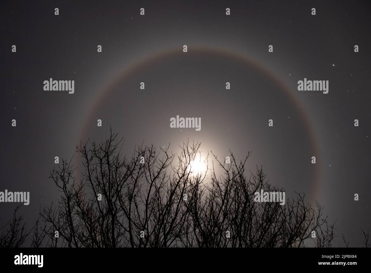 Halo phenomenon on the moon over Ukraine at night during the war in the country 2022, night moon and stars as a background Stock Photo