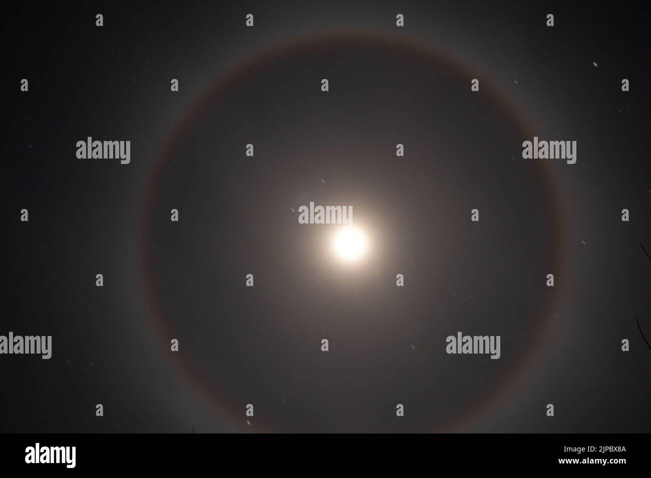 Halo phenomenon on the moon over Ukraine at night during the war in the country 2022, night moon and stars as a background Stock Photo