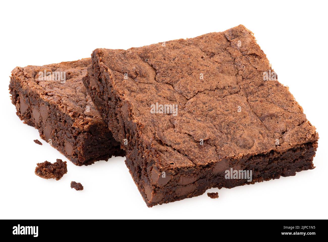 Two chocolate brownies with chocolate chips next to crumbs isolated on white. Stock Photo