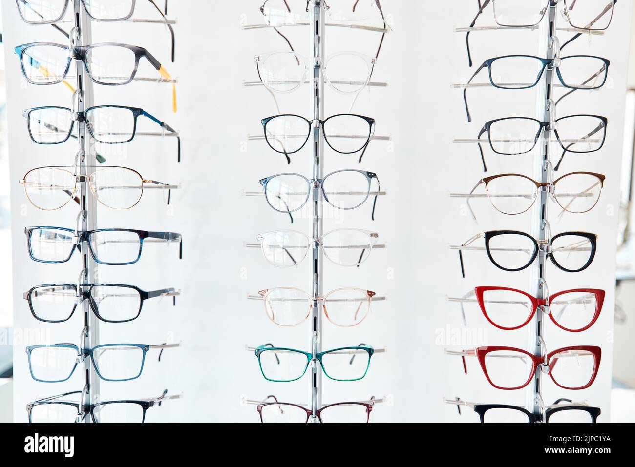 Glasses, optometrist and shelf with new, trendy and colorful spectacles in a display window in the retail and eye care industry. Window shopping Stock Photo