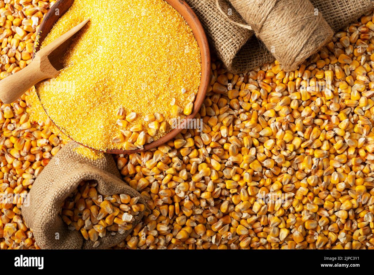 Yellow corn kernels with clay bowl in burlap sack flat lay Stock Photo