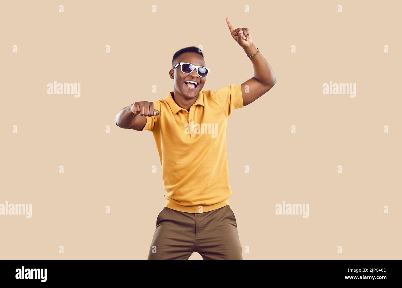 Studio portrait of happy handsome young African American man dancing and having fun Stock Photo