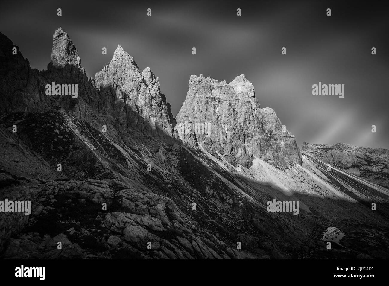 Black and white view of lake at the foots of rocky ridges of Pala di