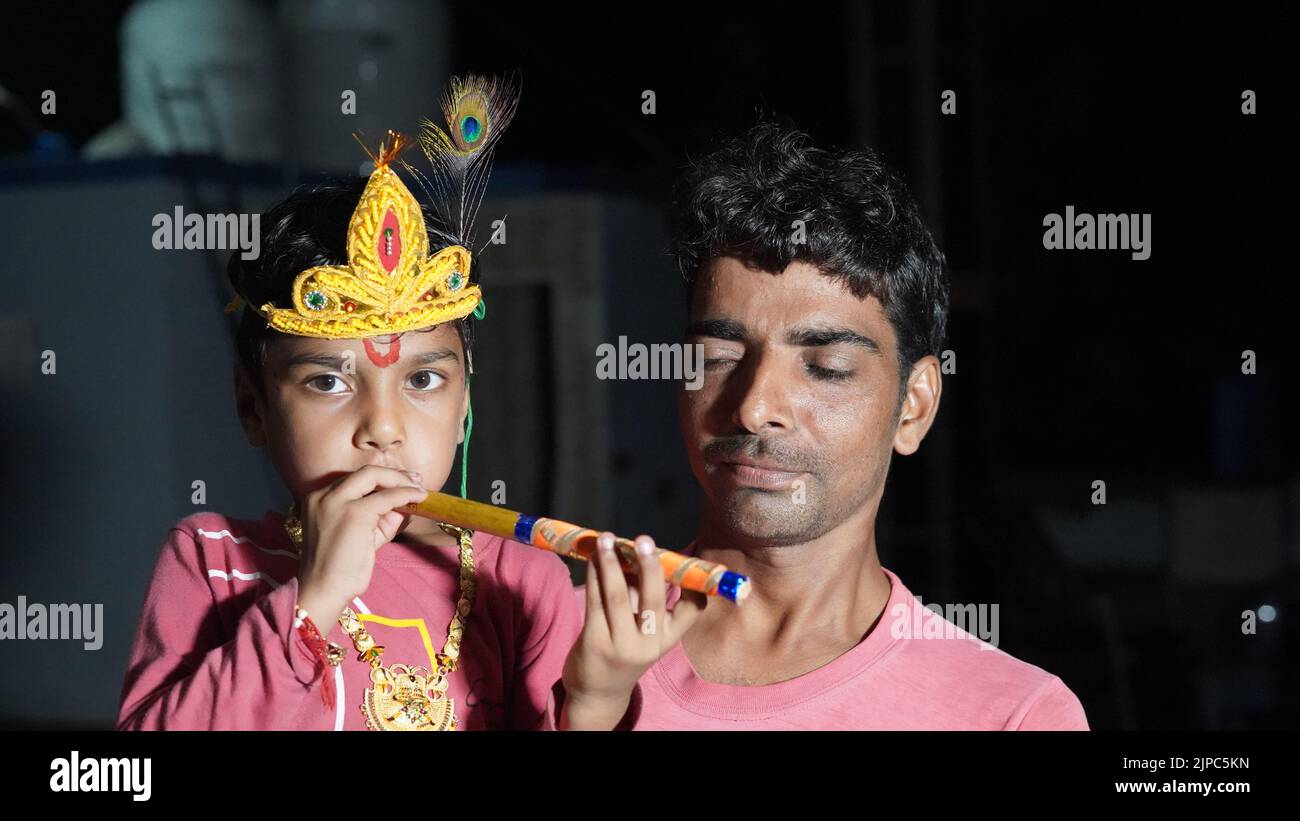 Father holding his son on krishna janamasthmi festival. Adorable baby boy dressed up as Little Krishna Stock Photo