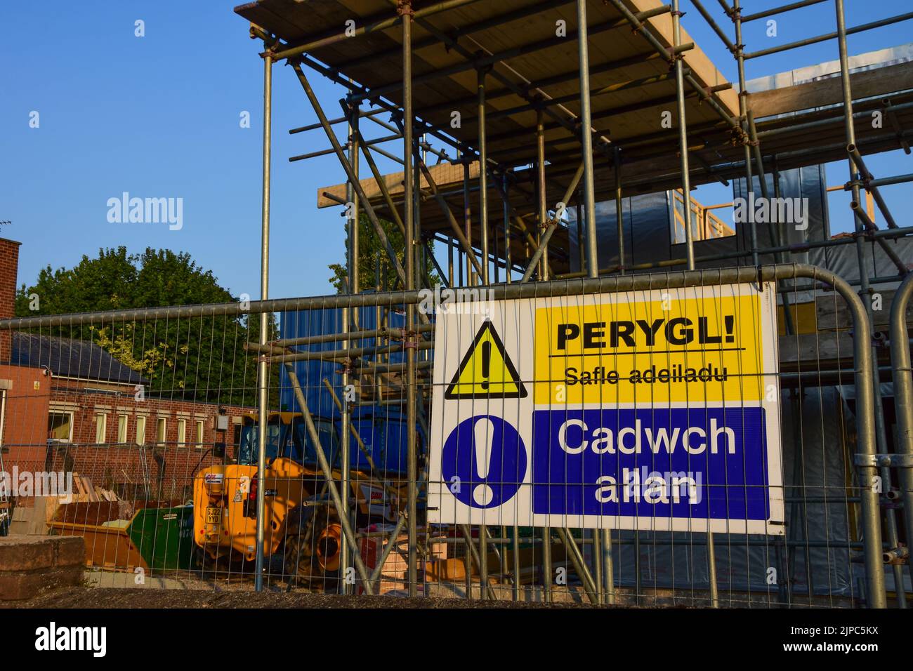 Holywell, Flintshire, UK: Aug 14, 2022: A warning sign on fencing at a building site. The sign is Welsh language Stock Photo