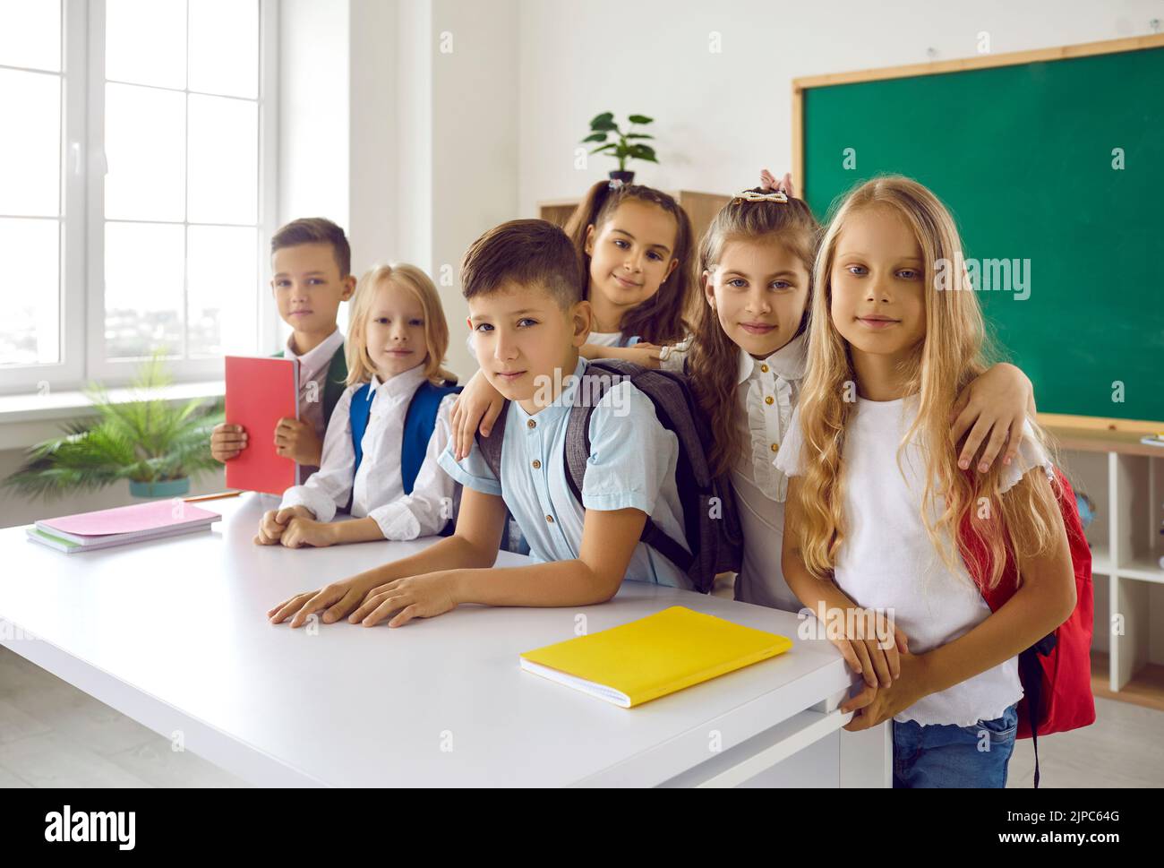 Cute group elementary school children posing in classroom for joint portrait together with friends Stock Photo