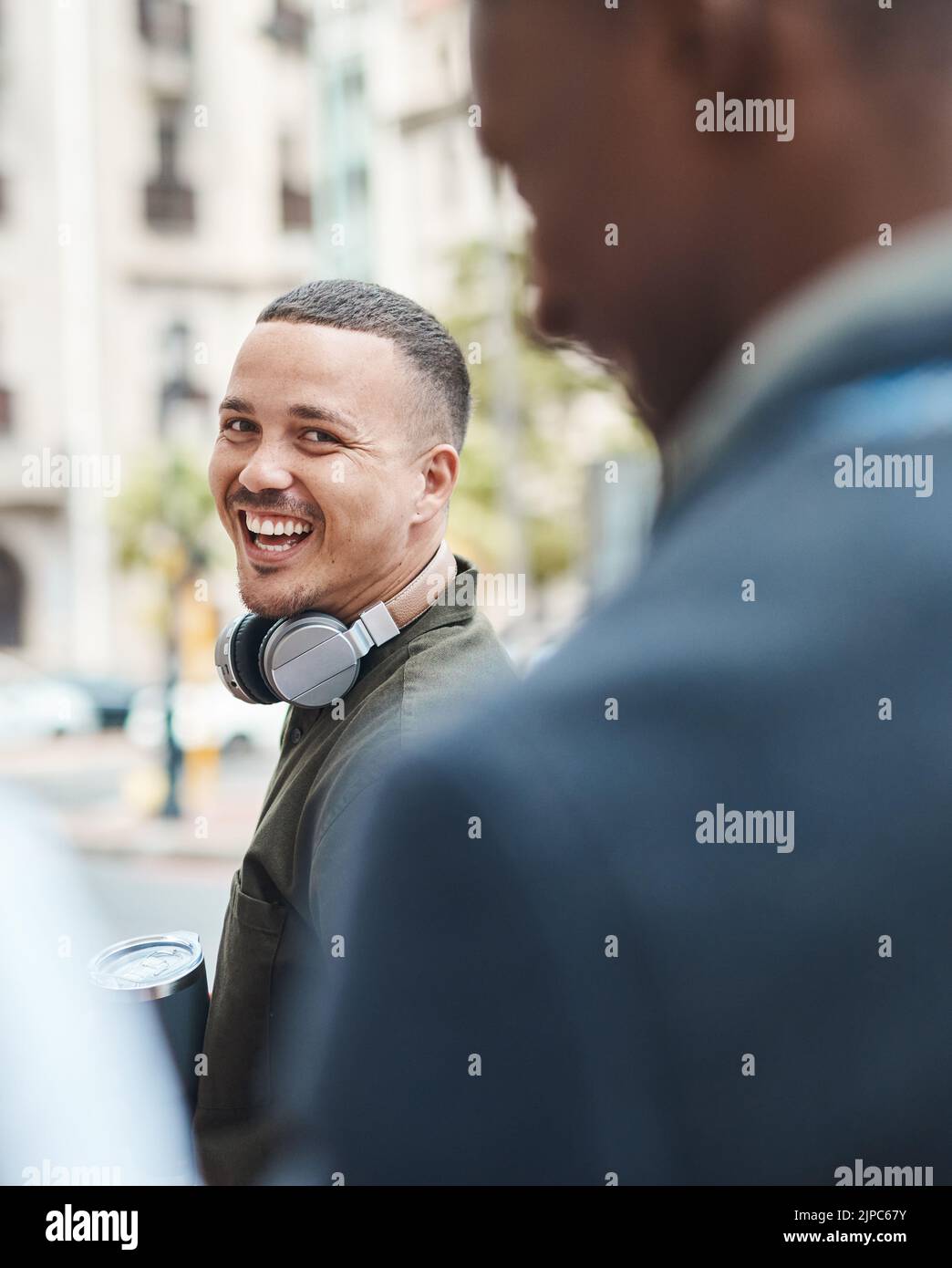 Real life young man portrait in the street with headphones, enjoying music on a playlist app looking happy, stressless and cool. Normal face of a Stock Photo