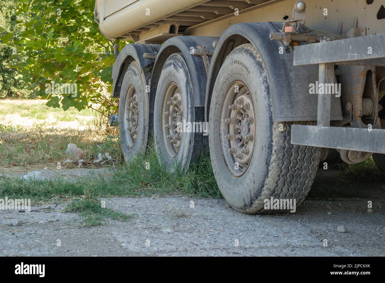 Parked truck trailers. The wheels of a truck trailer parked in a nearby