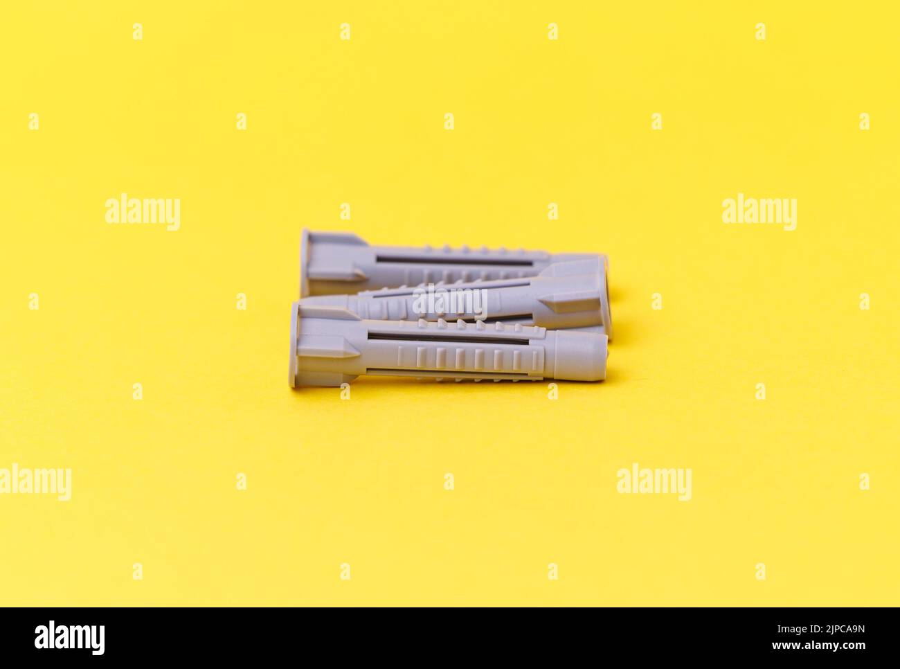Three Grey Wall Plugs isolated on the yellow background Stock Photo Alamy