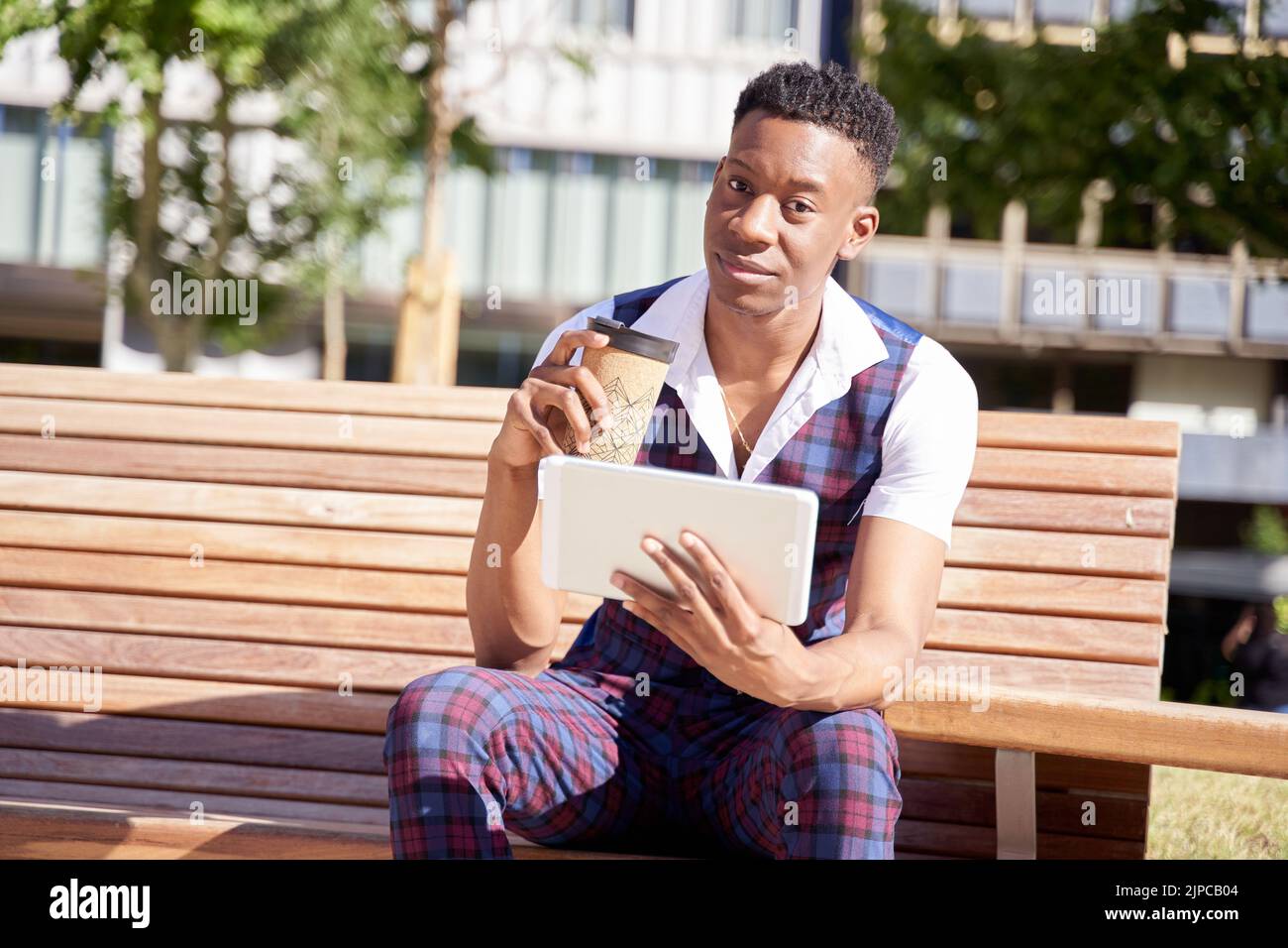 african american young man with tablet computer and take away coffee Stock Photo