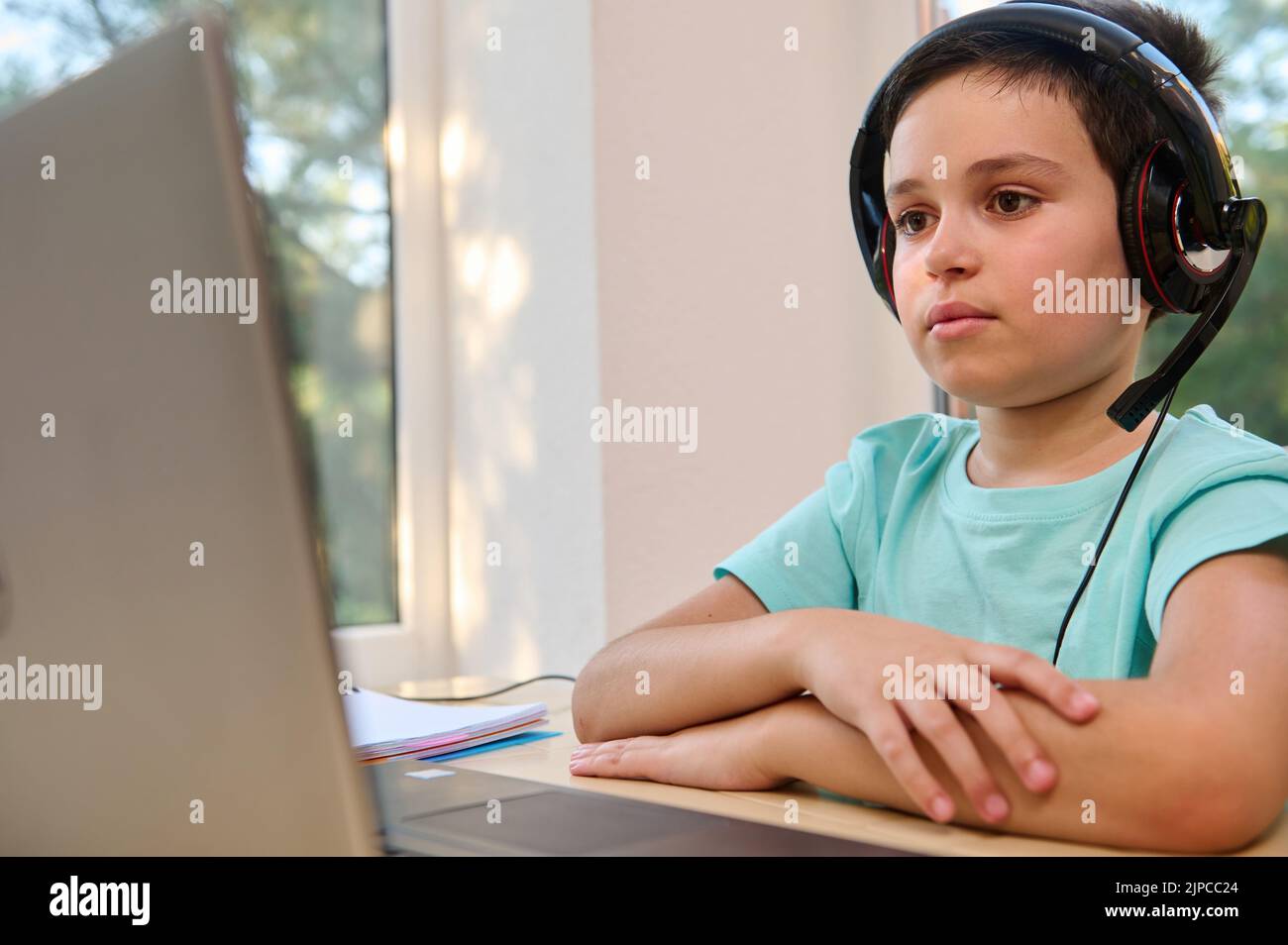 Smart teenage boy, schoolchild using laptop for video call with teacher. E-education. Distance learning in online school Stock Photo
