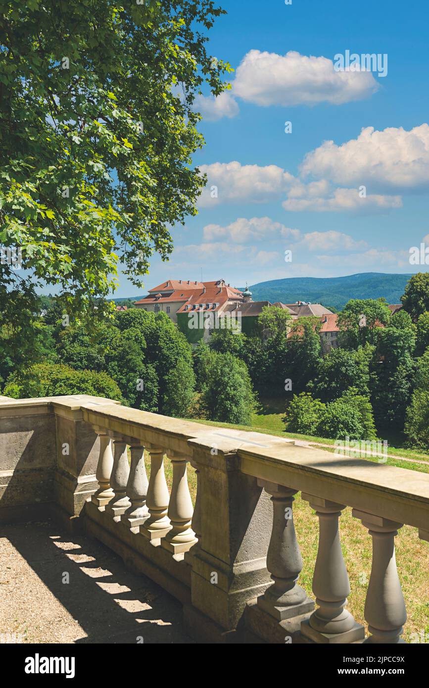 Morning Railing Shot A vertical shot of a tree and concrete railings with a mansion in the ...