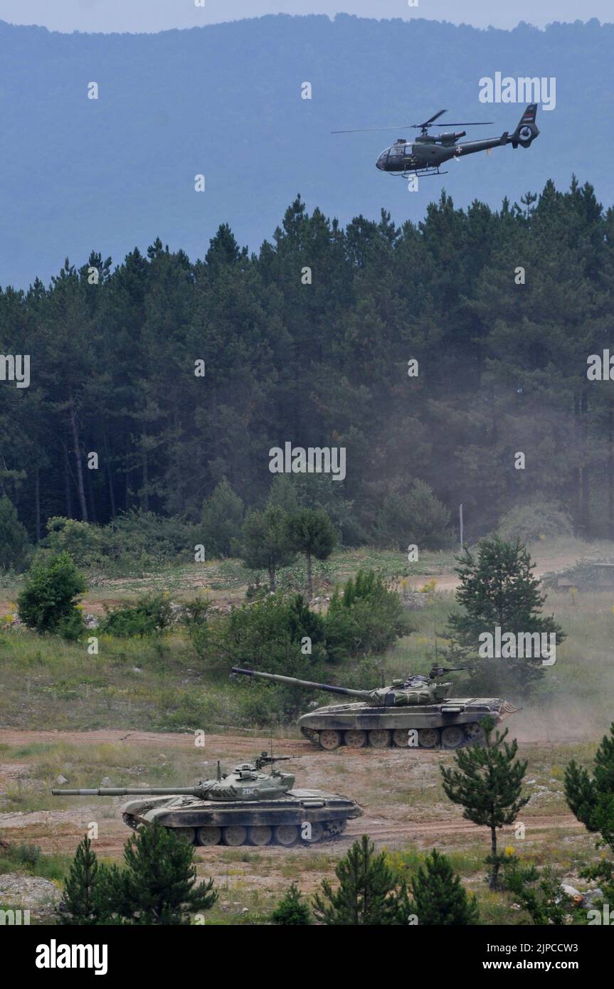 Serbian Army main battle tank M84 (version of Soviet T-72) and M80 armored personal carrier (APC) crews during exercise drill at military range Stock Photo