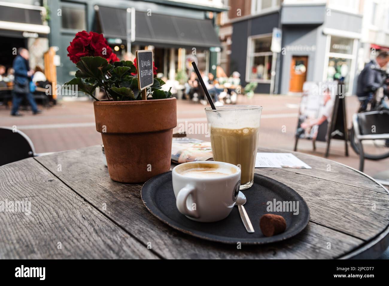 Cup and coffee and glass of iced coffee in sidewalk cafe in the historic centre of Haarlem