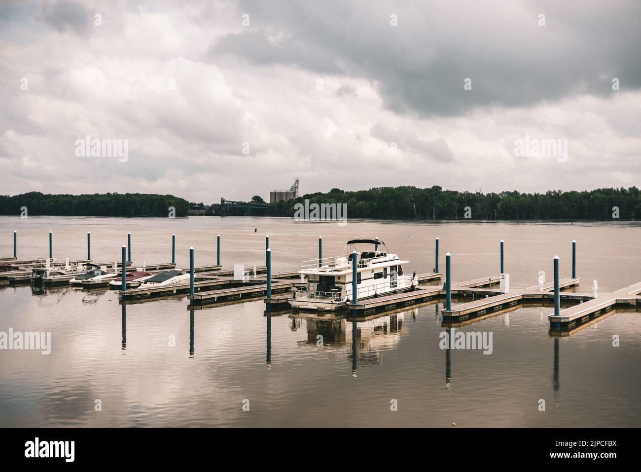 The docked ship reflected on the water under the cloudy sky on a rainy ...