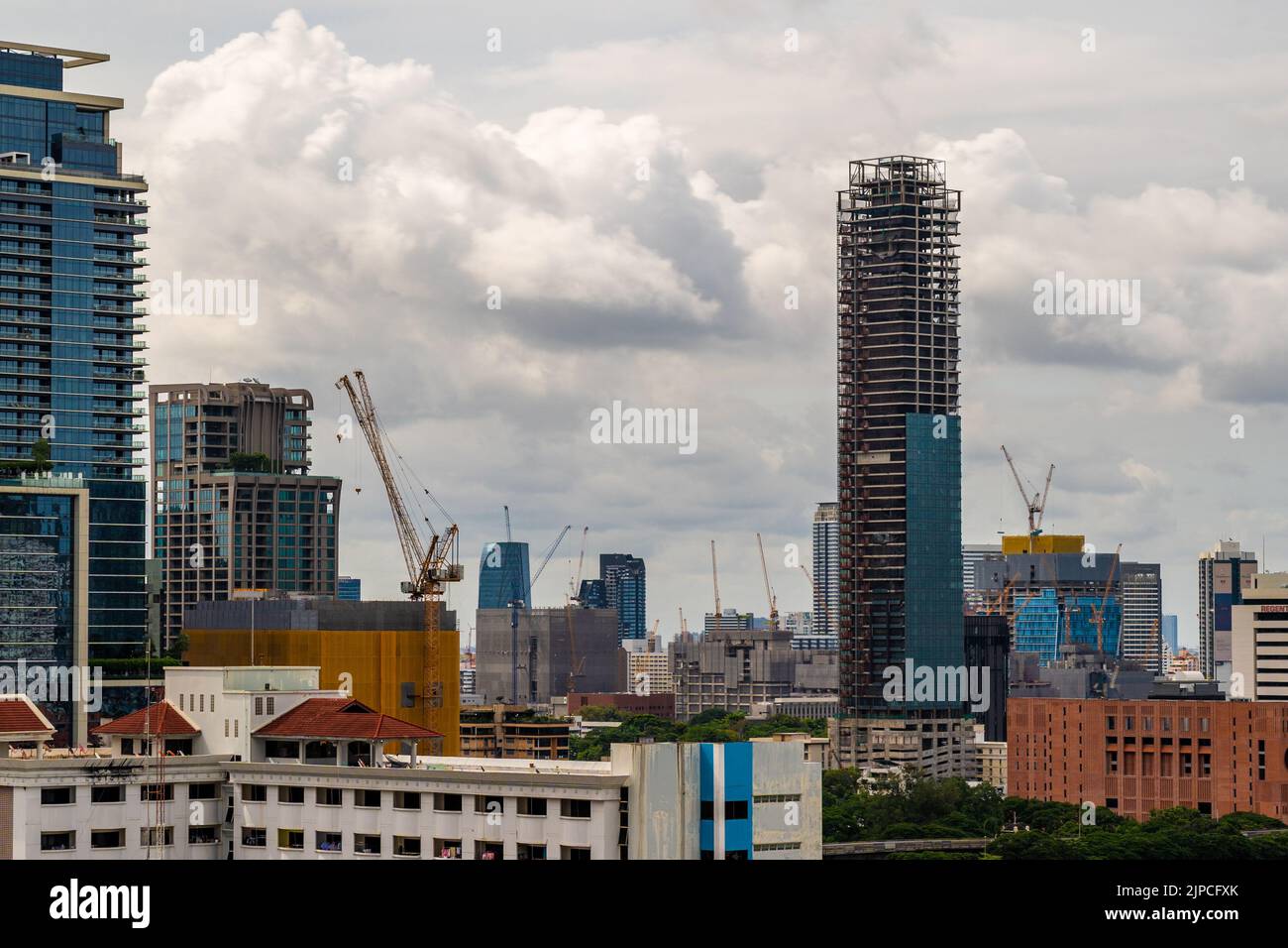 Bangkok, Thailand - 12  August 2022 - Large working construction cranes working on building high-rise buildings in Bangkok, Thailand Stock Photo