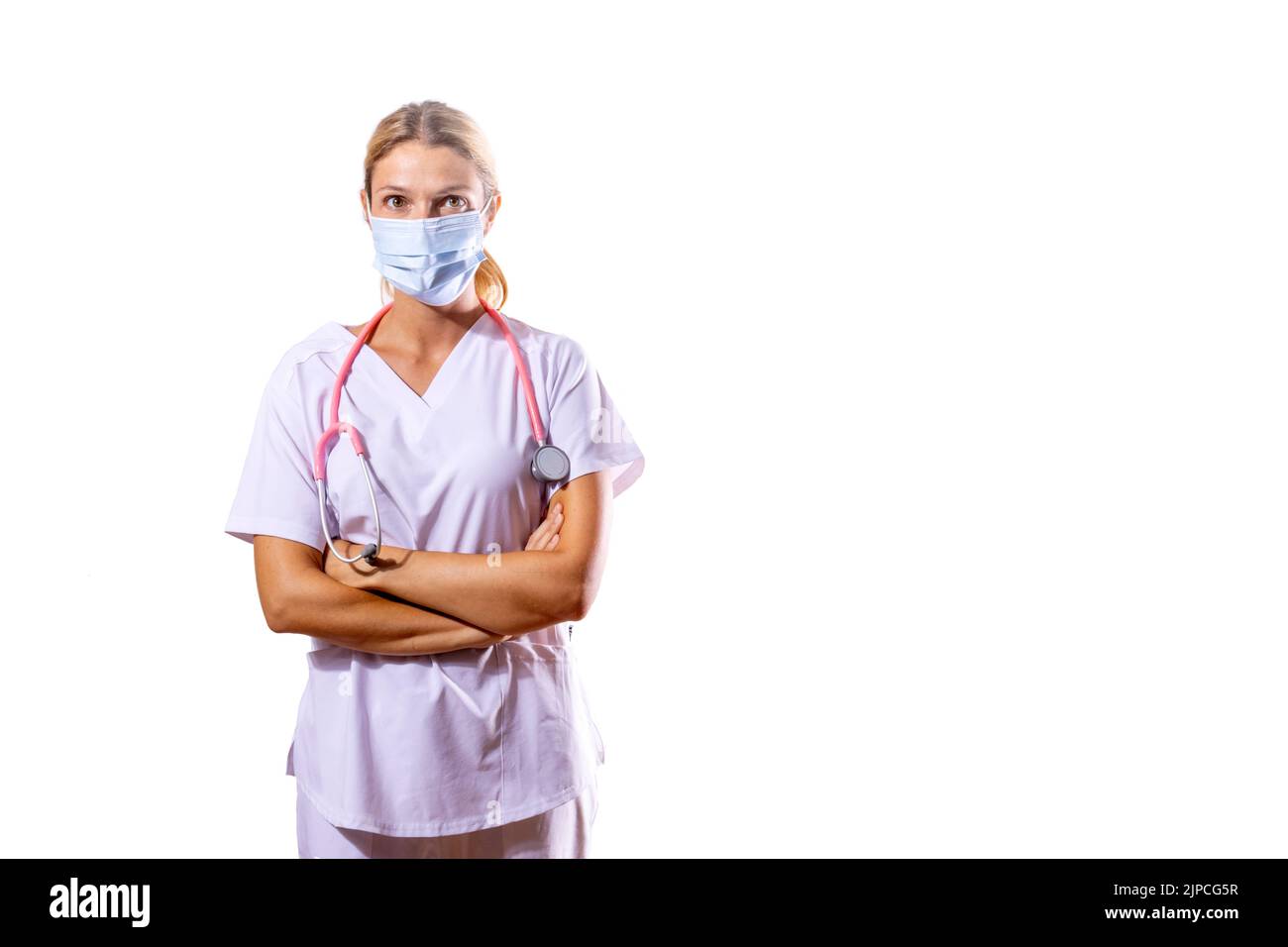 medical girl adjusting her surgical mask. Health concept. Coronavirus. COVID-19. Pandemic. White background and copy space Stock Photo