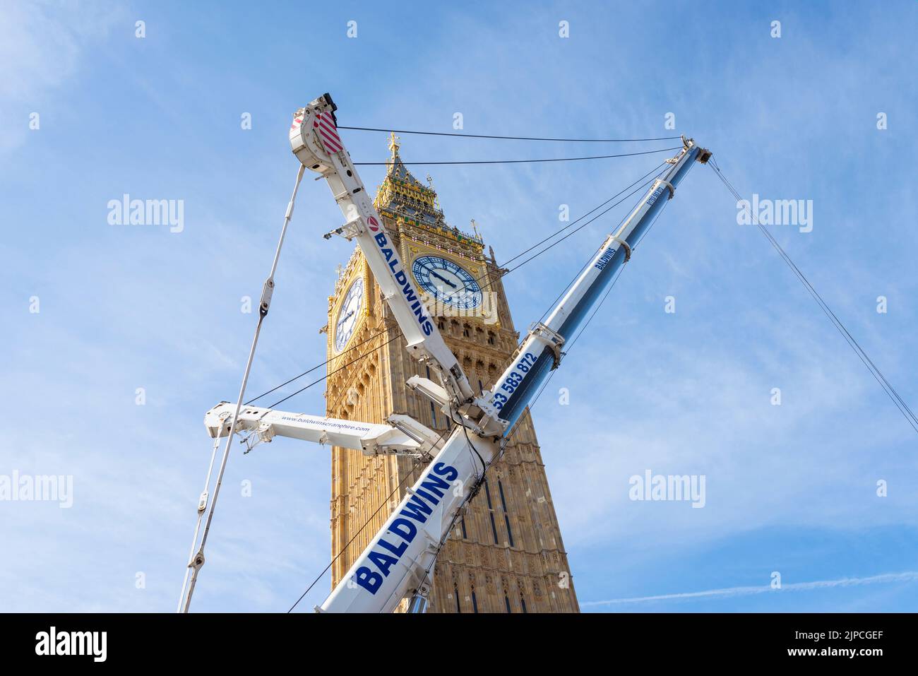 Large Baldwins crane removing the final sections of scaffolding from the restored Elizabeth Tower, Big Ben, of Palace of Westminster, London, UK Stock Photo