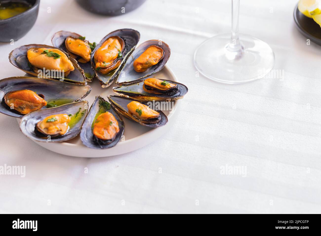 Steamed black mussels cooking in sauce and served with wine. Popular  Mediterranean seafood dish background. Stock Photo