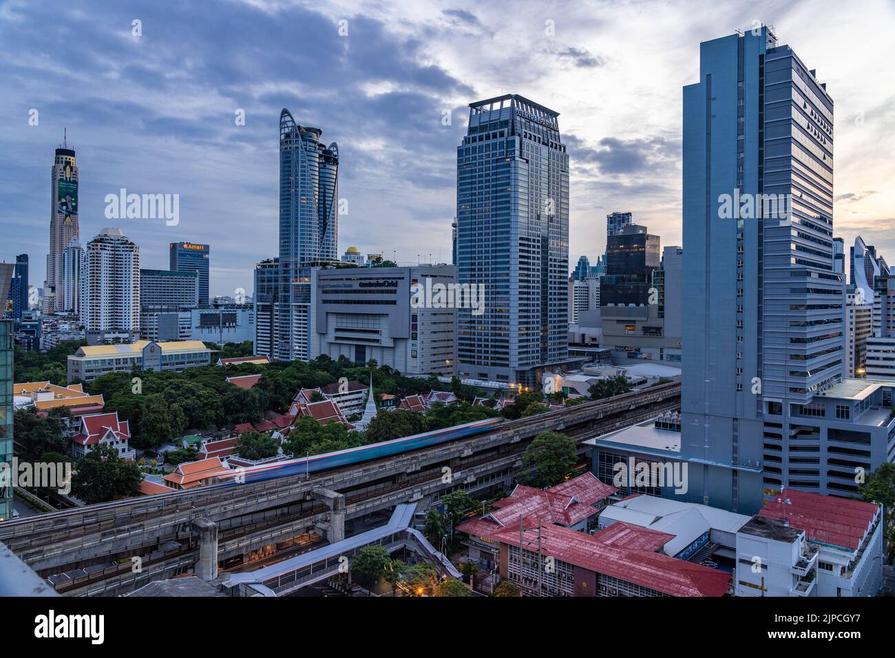 Bangkok, Thailand - 11 August 2022 - Aerial view of Bangkok cityscape in the morning before sunrise showing high-rises and running BTS skytrains and c Stock Photo