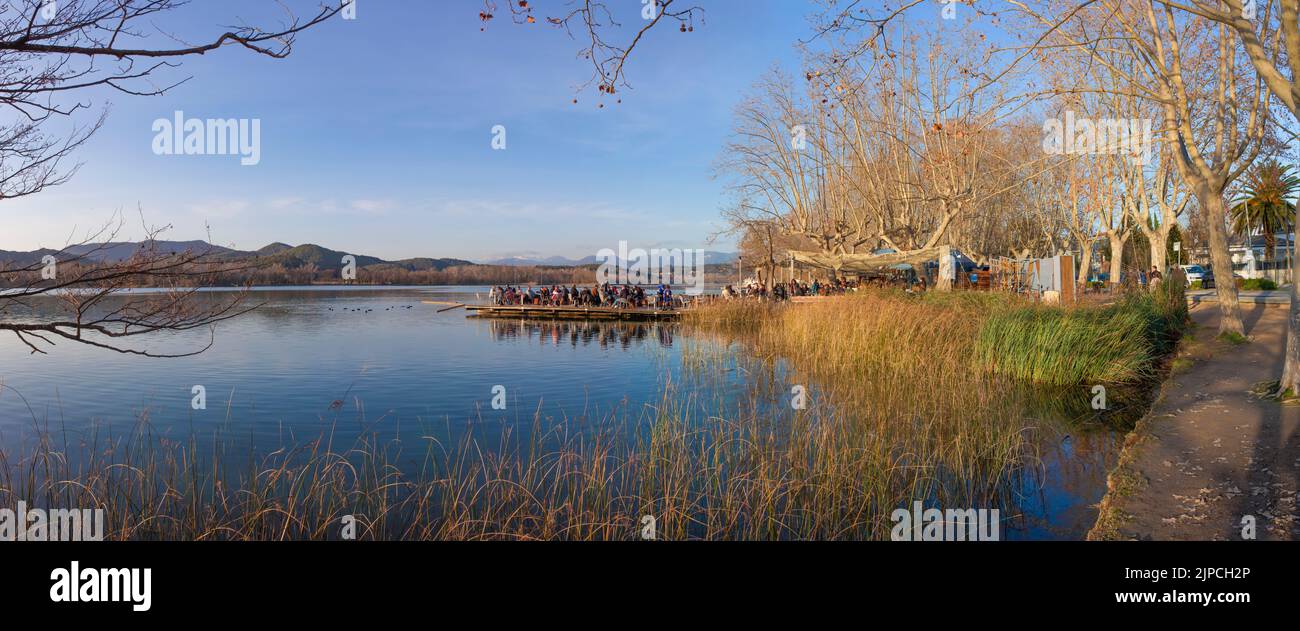 People enjoying the winter sun over pier restaurant at  Lake of Banyoles, Girona, Catalonia, Spain Stock Photo