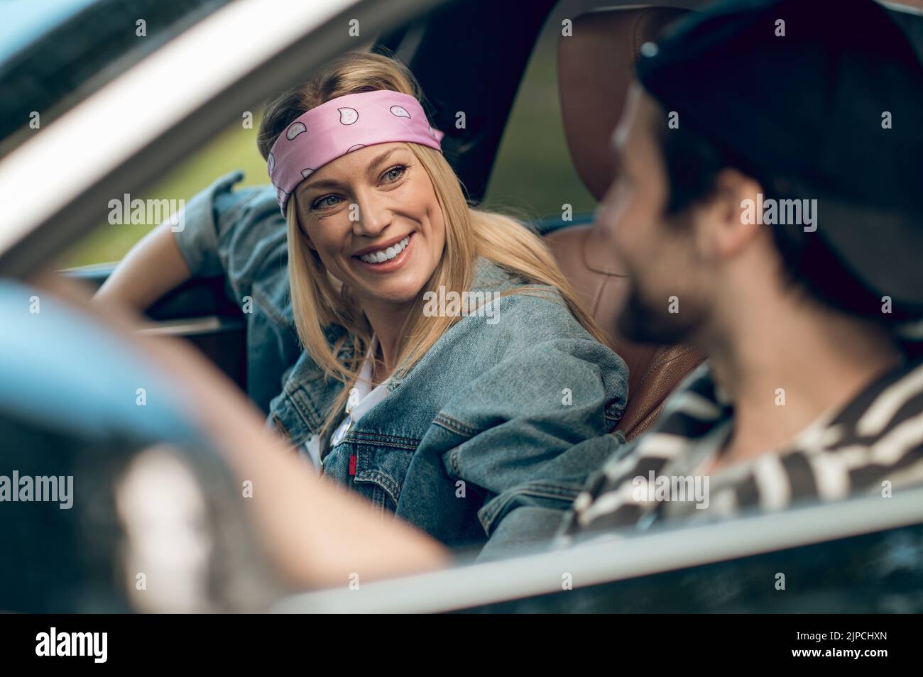 Smiling couple driving in a car and looking at each other Stock Photo