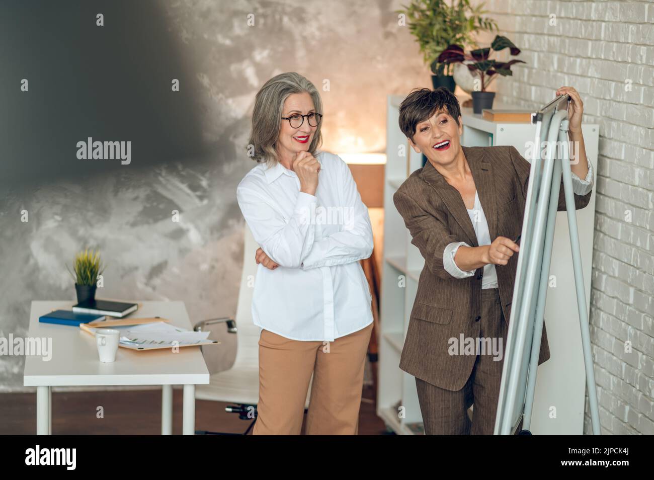 Colleagues discussing project details and looking involved Stock Photo