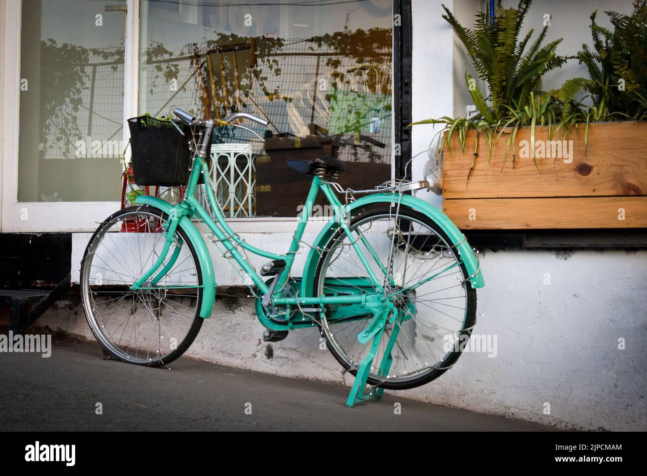 January 1st 2020 Mussoorie Uttarakhand India. A light green antique decorative ladies bicycle with basket outside a cafe for decorative purposes. Stock Photo