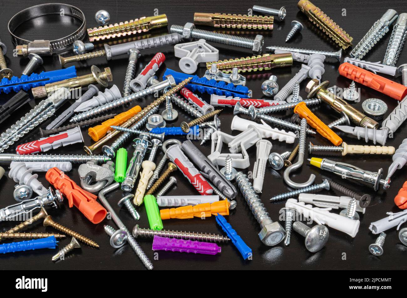 Different types of fasteners on a dark wood background. Front view