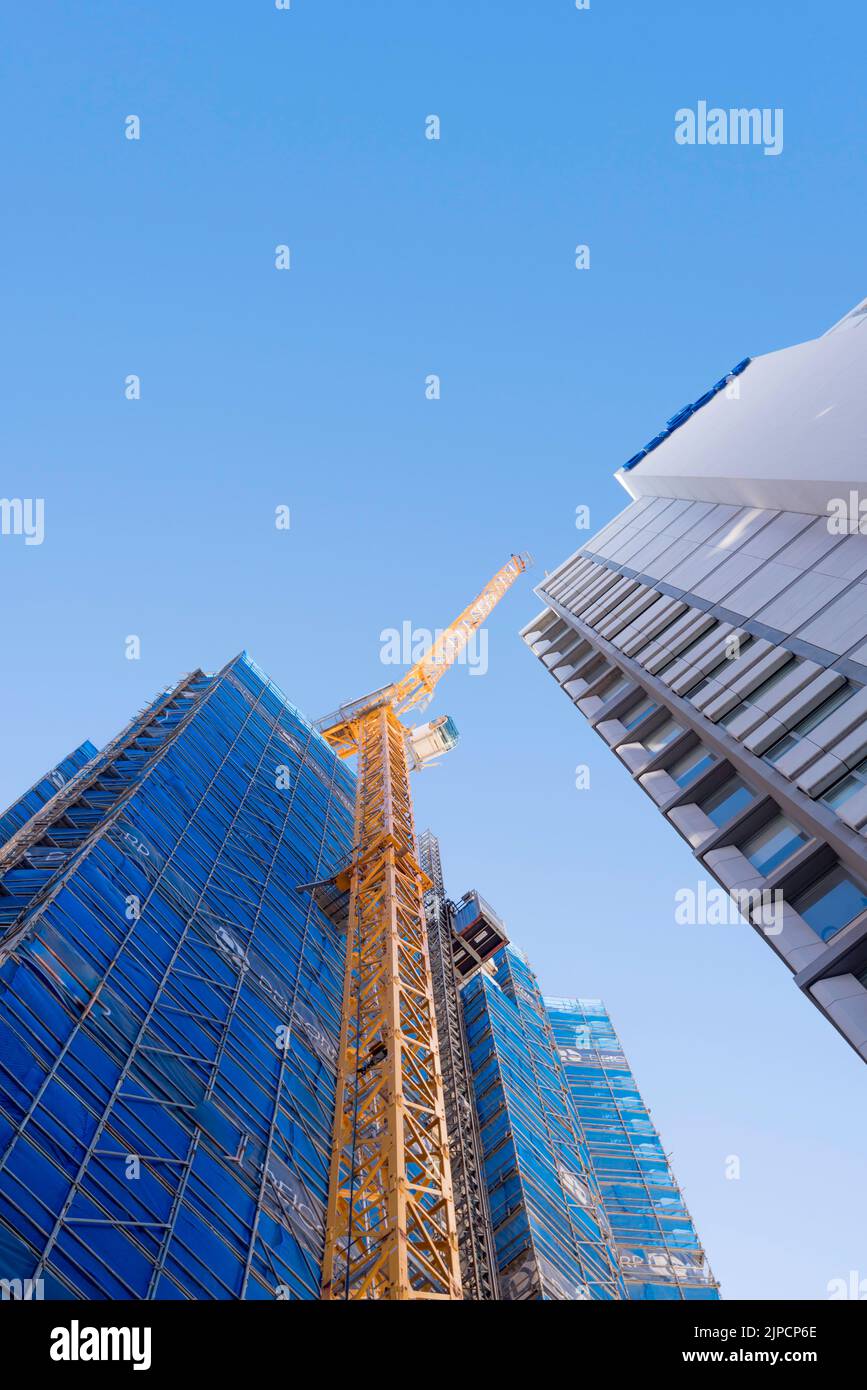 Looking up at a tall luffing crane attached to a new building being constructed in Redfern, New South Wales, Australia Stock Photo