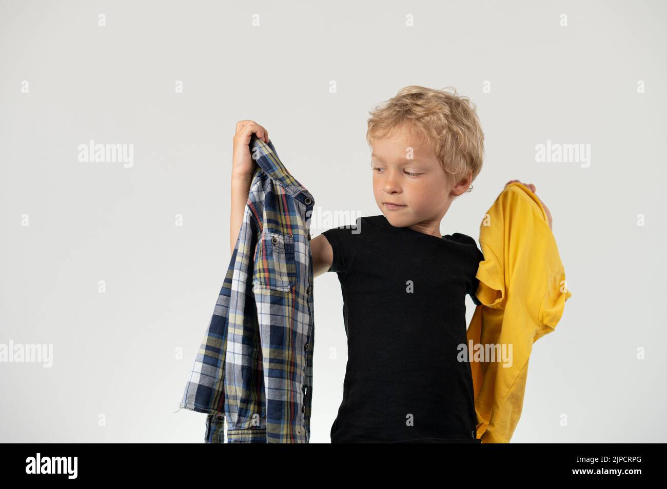 Boy deciding what cloth to put on Stock Photo