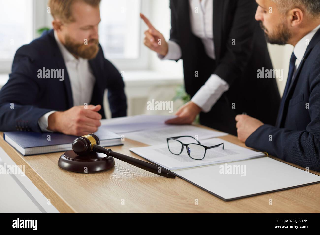 Meeting in office of team of lawyers and their client to discuss legal case or consult notary. Stock Photo