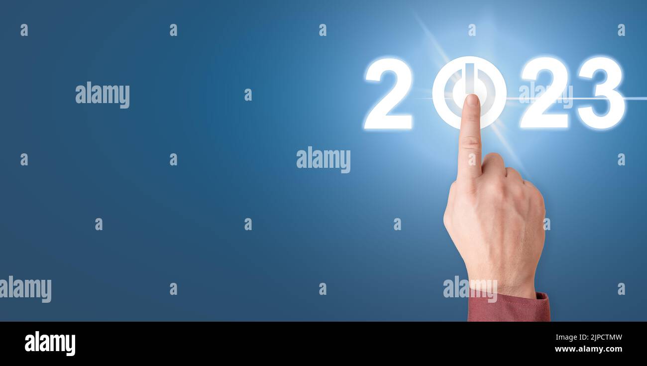Finger pressing start 2023 button on virtual interface. Businessman pressing 2023 start up business. Happy New Year button technology virtual innovati Stock Photo