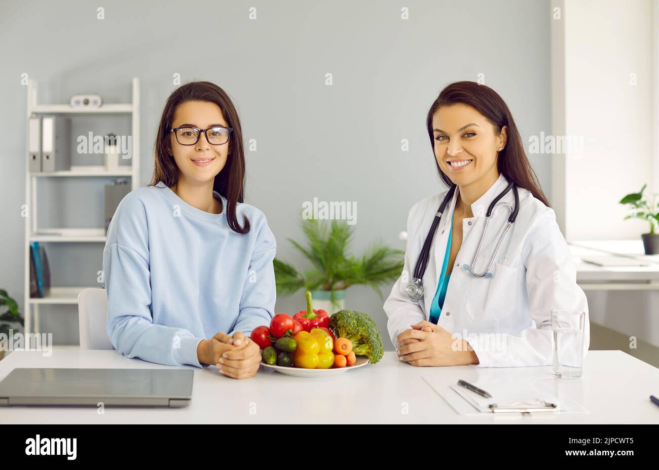 Professional dietitian or nutritionist giving consultation about healthy food to young woman Stock Photo