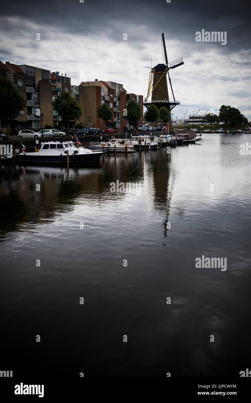 Vintage windmill across the water in Delfshaven district of Rotterdam Stock Photo