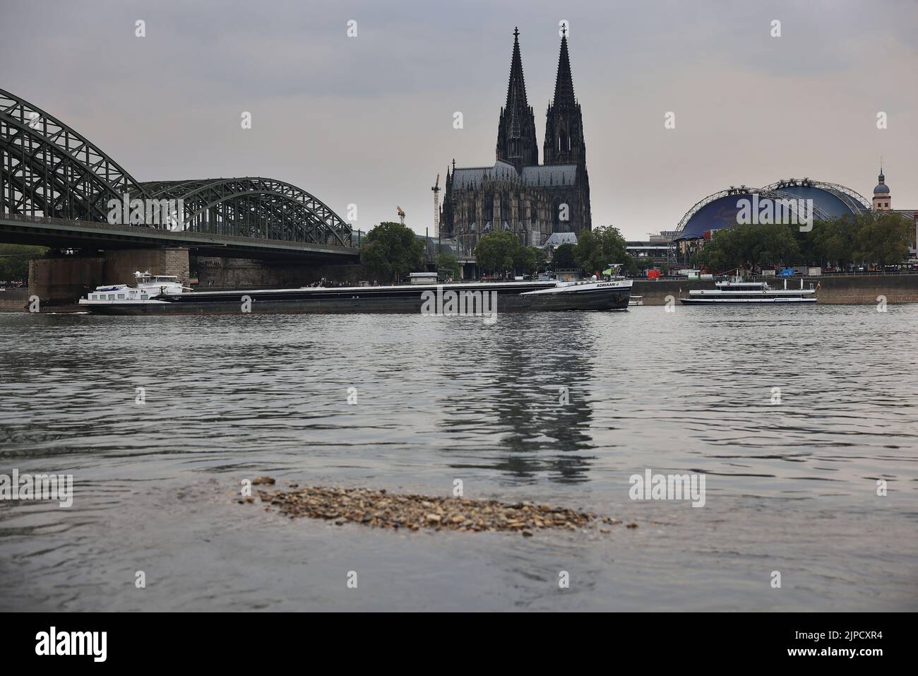 Cologne, Germany. 17th Aug, 2022. A ship sails across the Rhine under the Hohenzollern Bridge past Cologne Cathedral at low tide. The people of Cologne have been closely connected with the Rhine for 2000 years. The river was even considered sacred to them. And their greatest fear has always been that it might one day disappear. (To dpa/lnw: 'Between trickle and tsunami - The people of Cologne and the sacred river') Credit: Oliver Berg/dpa/Alamy Live News Stock Photo