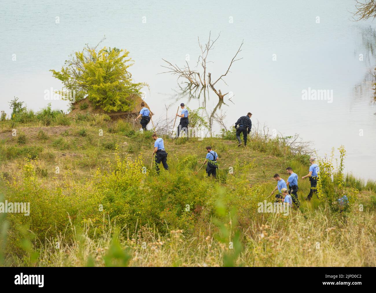 Echzell, Germany. 17th Aug, 2022. Officers of the riot police search the shore of the Teufelsee in the Wetterau district of Hesse, where the body of 14-year-old Ayleen was found. The special commission 'Lacus' hopes to discover further crime-relevant traces, police and public prosecutor's office announced. In addition to the riot police, police divers from Rhineland-Palatinate, a sonar boat of the German Lifesaving Society and a drone were deployed. Credit: Frank Rumpenhorst/dpa/Alamy Live News Stock Photo