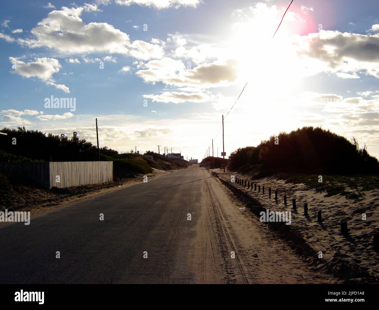 An empty road in Quequen under a blue cloudy sky on a sunny day Stock Photo
