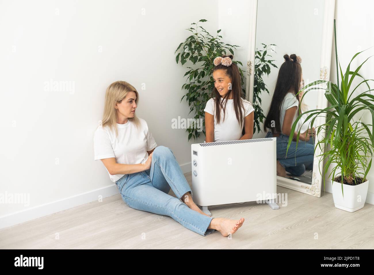 Electric heater at home. Young family warms his frozen hands near a