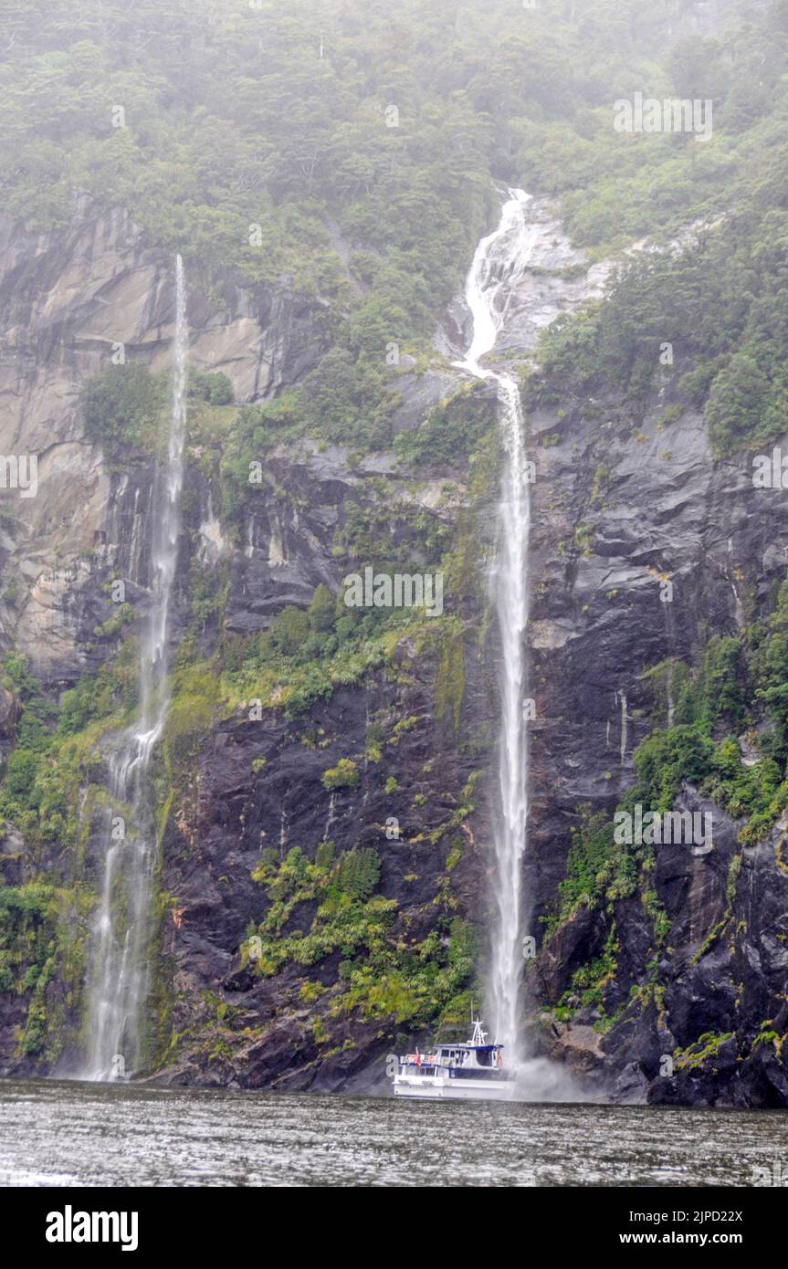 The bow of a  cruise boat, MV Sinbad, touching the full force of water from the 155m high Stirling Falls for the benefit of its passengers on Milford Stock Photo