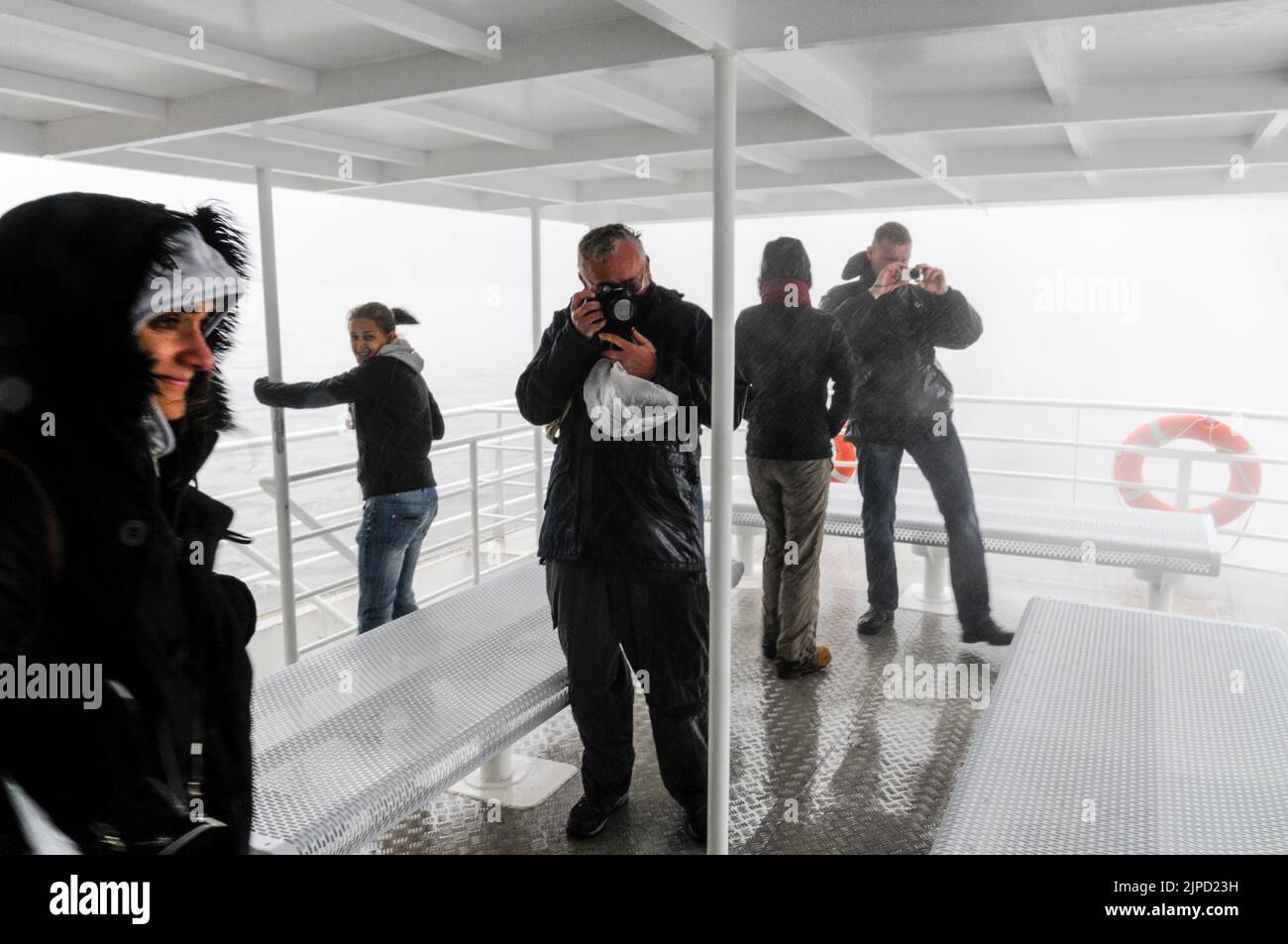 Some of the onboard tourists were brave enough to experience the powerful spray as the cruiser ship edges closer to the 155 m tall Stirling Falls on M Stock Photo