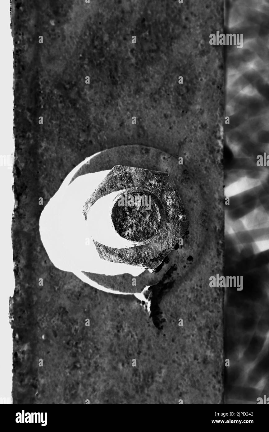 Single nut and bolt holding a steel metal plate together in black and