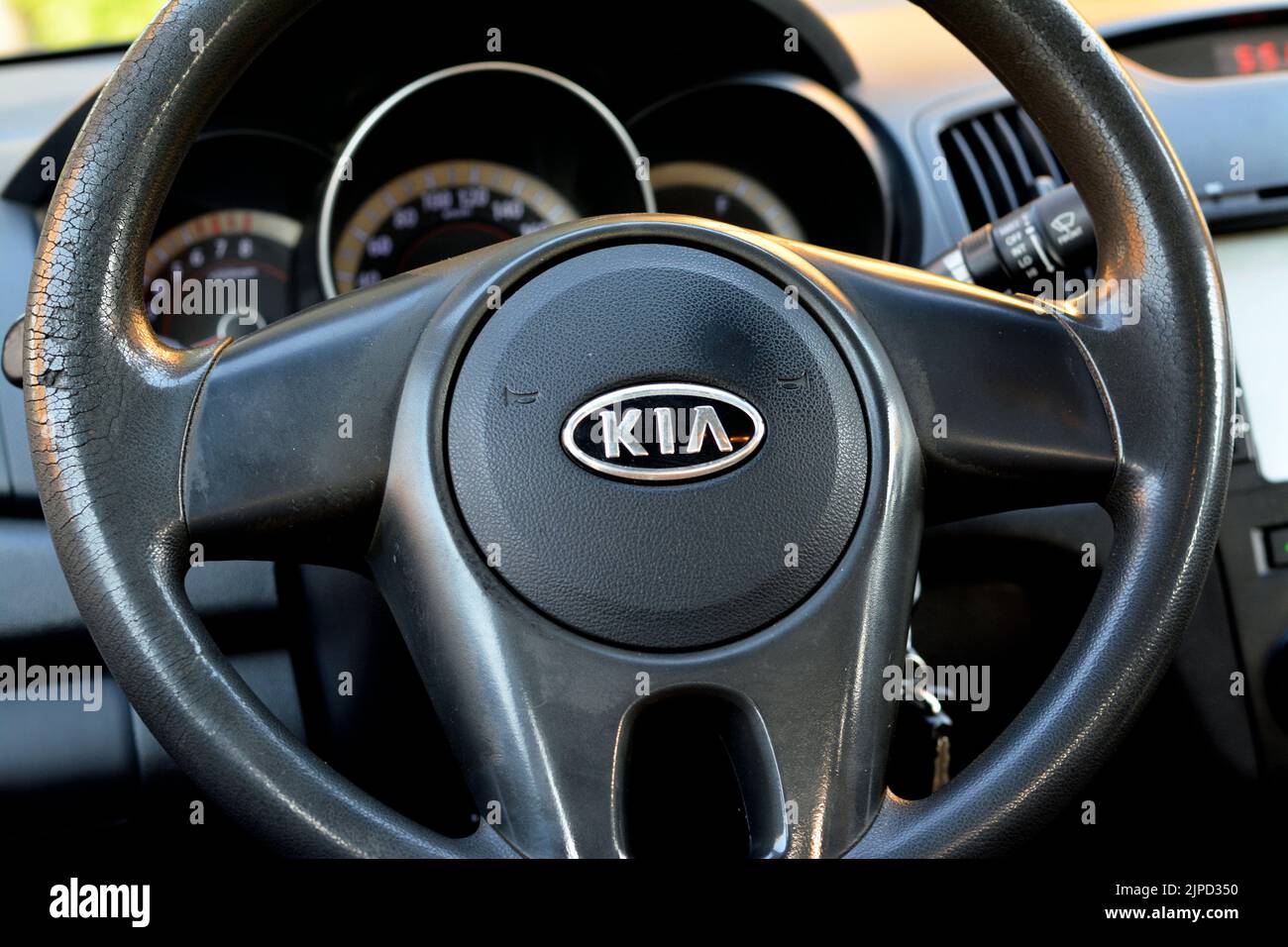 Cairo, Egypt, August 5 2022: A close up of KIA logo from an interior of KIA cerato 2011 first line with the vehicle dashboard and a leather steering w Stock Photo