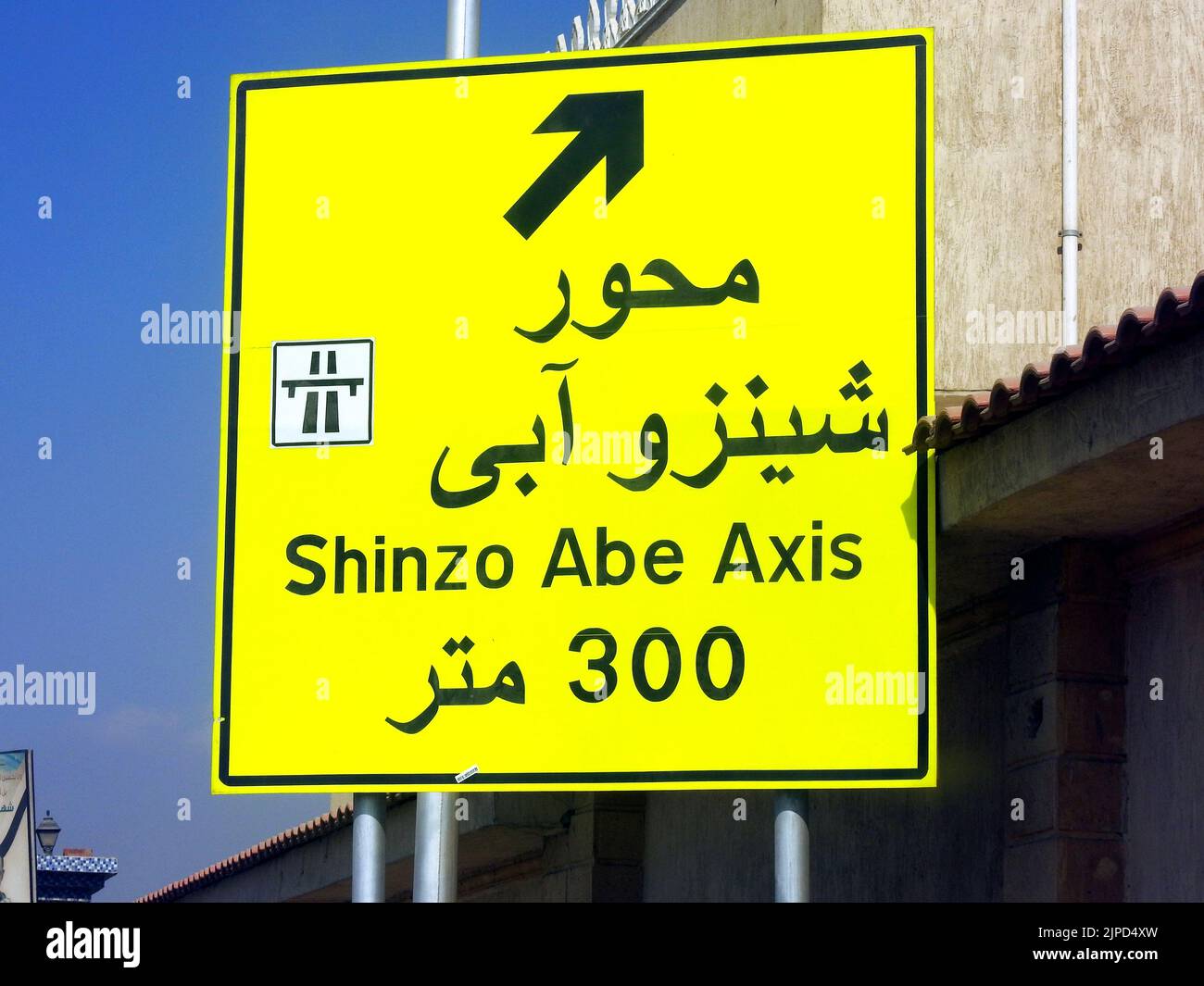 Cairo, Egypt, July 31 2022: A direction road sign in Egypt, Translation of Arabic text (Shinzo Abe Axis 300 meters), new patrol highway named on forme Stock Photo