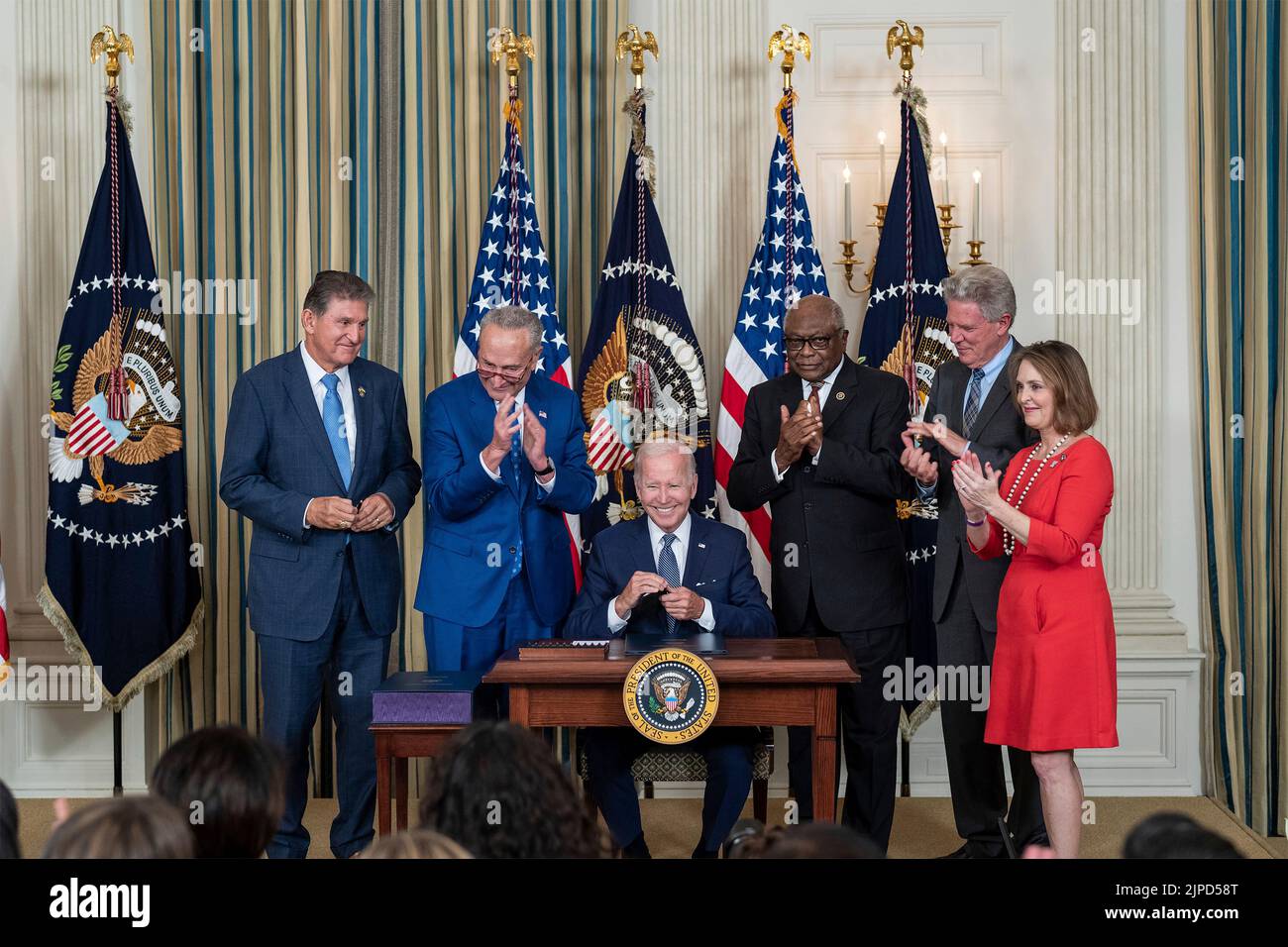 Washington, United States Of America. 16th Aug, 2022. U.S President Joe Biden, President Joe Biden signs the Inflation Reduction Act into law during a ceremony in the State Dining Room of the White House August 16, 2022 in Washington, DC Standing from left: Sen. Joe Manchin, Senate Majority Leader Chuck Schumer, House Majority Whip Rep. James Clyburn, Rep. Frank Pallone, and Rep. Kathy Castor. Credit: Planetpix/Alamy Live News Stock Photo